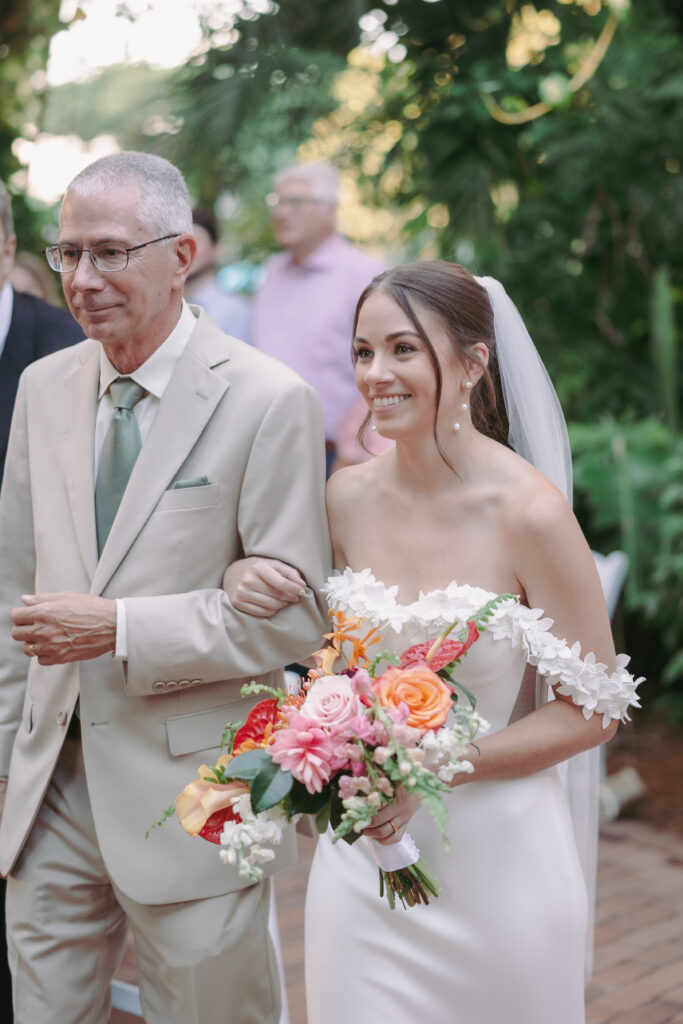 Bride walking down the aisle with her father at her dream wedding at the Hemingway House Museum, marking a heartfelt moment.
