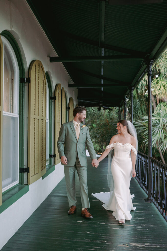 Couple looking at each other, walking hand in hand at their dream wedding at the Hemingway House Museum, capturing a moment of pure connection.