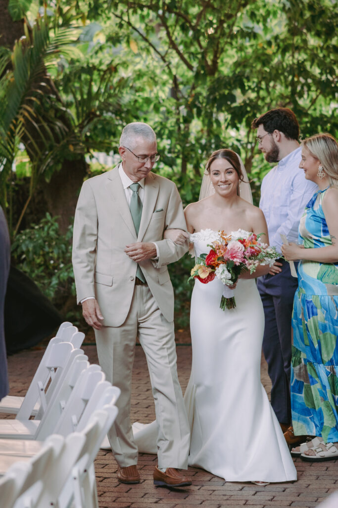 Bride walking down the aisle with her father at her dream wedding at the Hemingway House Museum, marking a heartfelt moment.