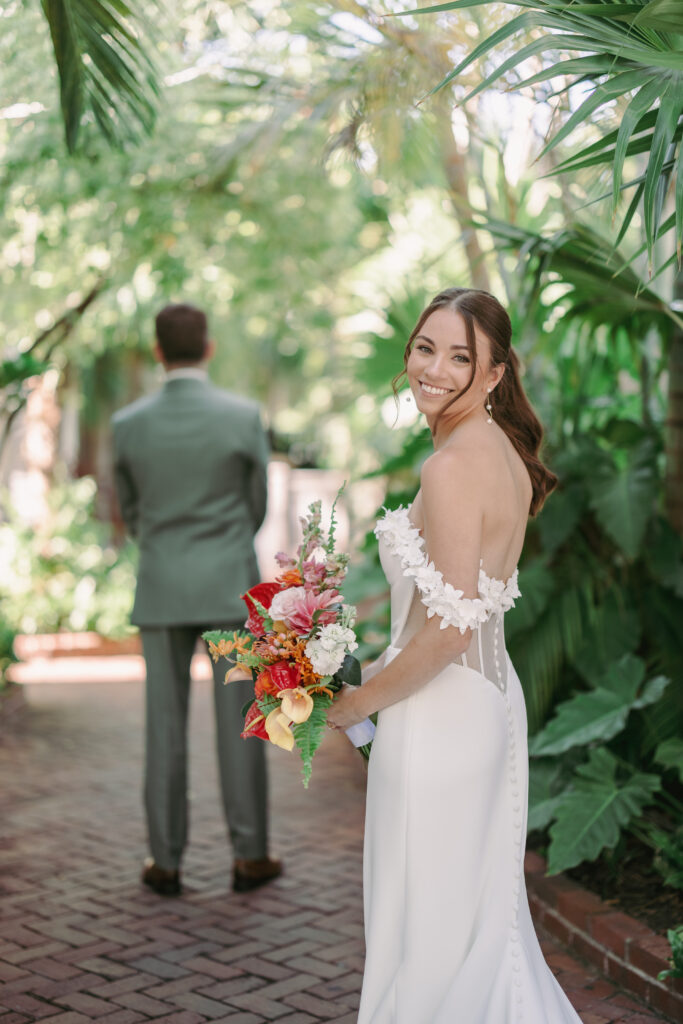 Bride gazing beautifully at the camera before her first look with the groom at their dream wedding at the Hemingway House Museum.