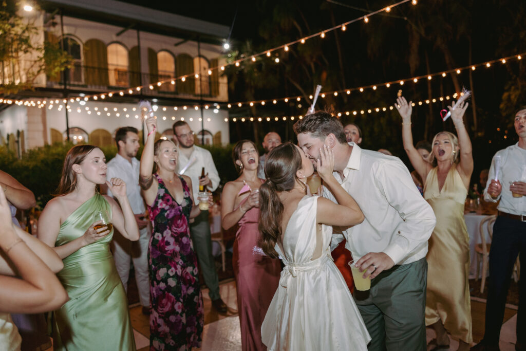 Guests enjoying the celebration as the couple shares a kiss on the dancefloor at their dream wedding at the Hemingway House Museum, creating a joyful and memorable moment.