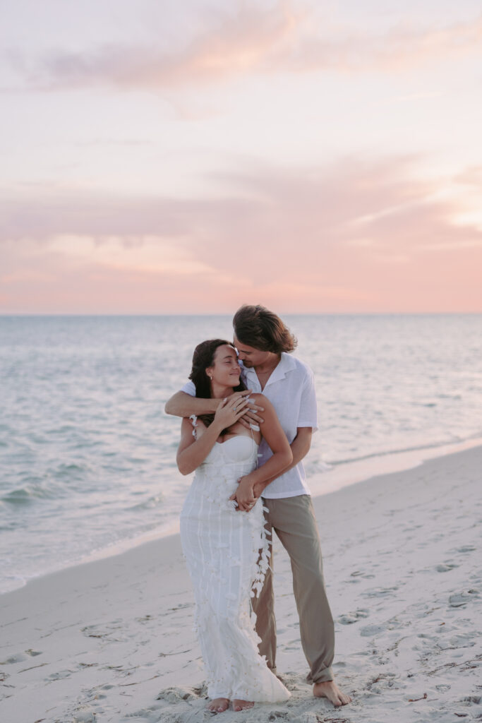 Couple embracing by the beach with a back hug during their Lifestyle Session in the Florida Keys.