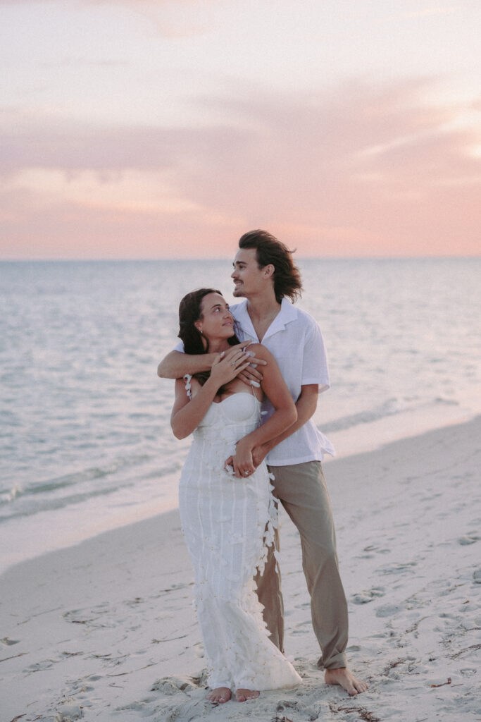 Couple embracing by the beach with a back hug during their Lifestyle Session in the Florida Keys.
