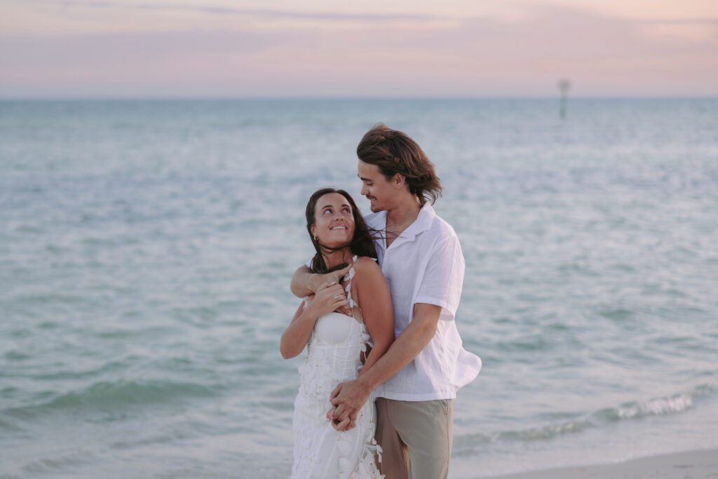 Couple embracing by the beach with a back hug during their Lifestyle Session in the Florida Keys.