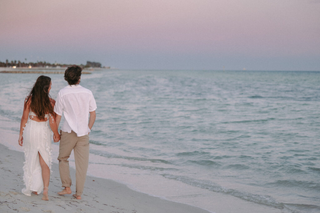 Couple strolling hand in hand along the shore during their Lifestyle Session in the Florida Keys.