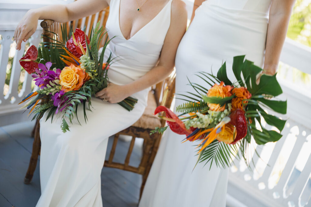 Two brides holding their tropical flower themed bouquets