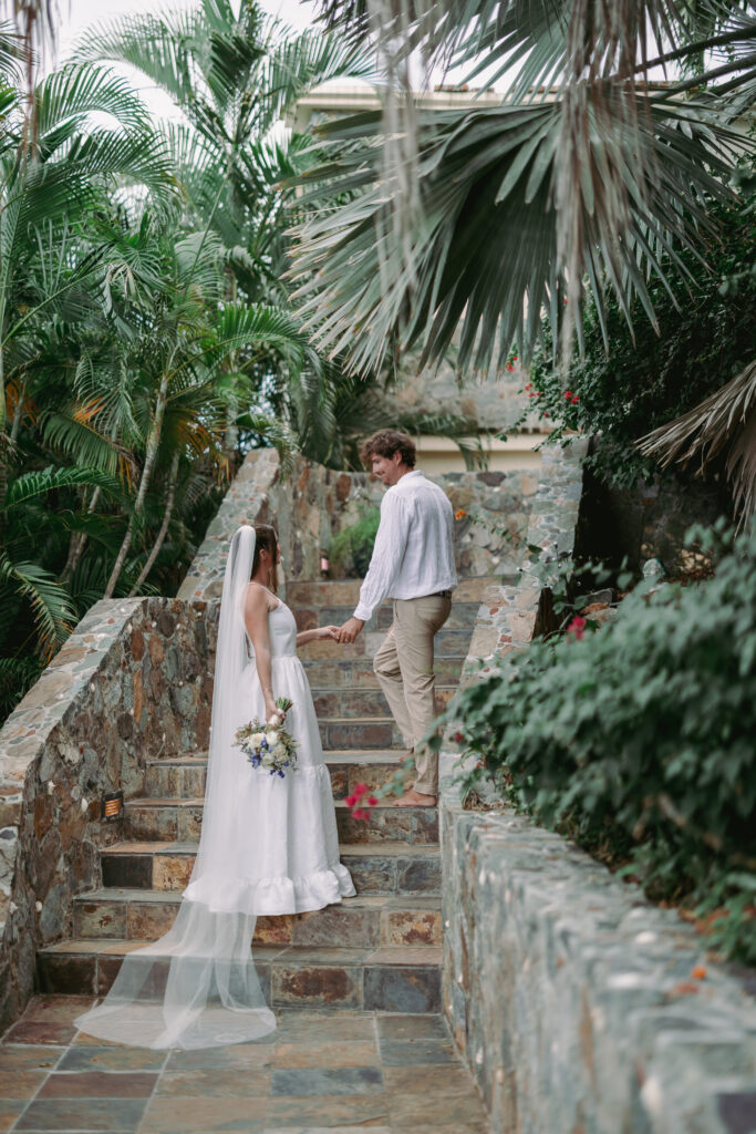 Bride and groom holding handings on the stairs outside a Cruz Bay villa during their St John USVI wedding