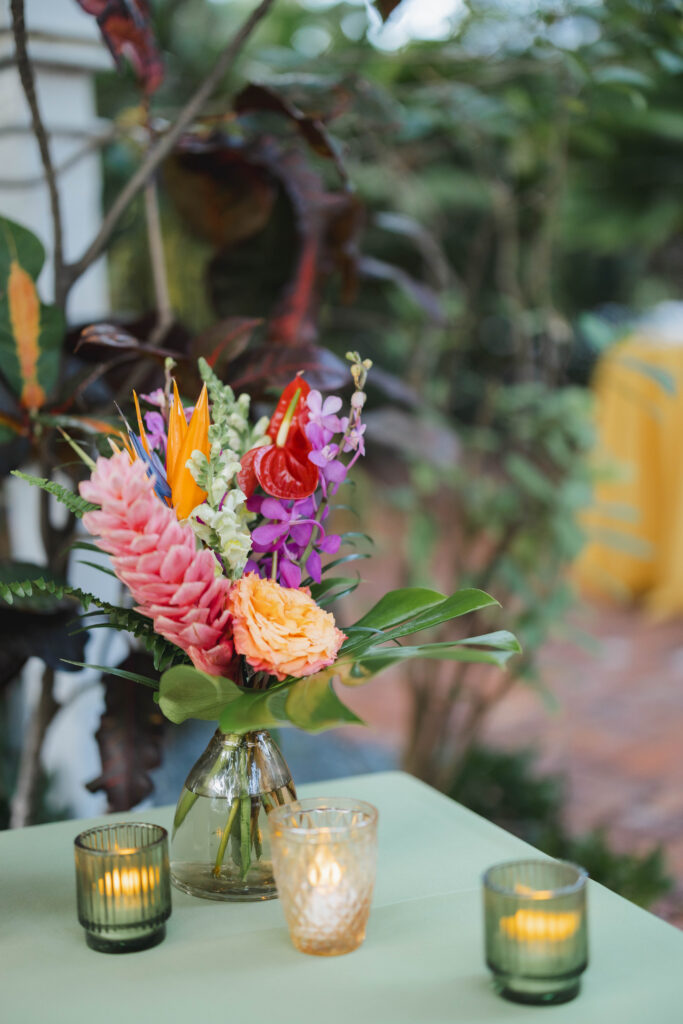 Lush, tropical themed floral displays on the table at an outdoors Key West wedding reception.