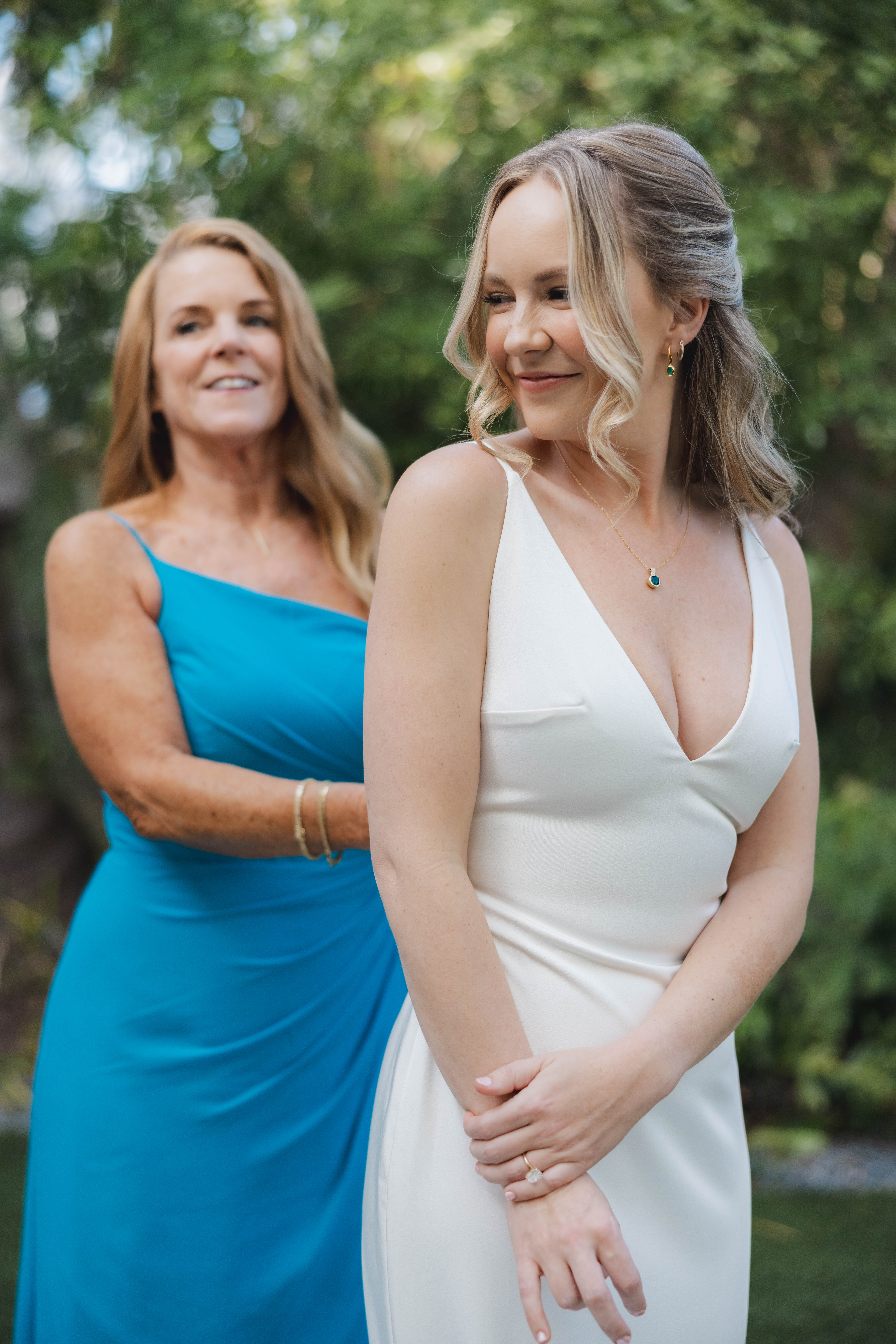 Mother buttoning up her daughter's dress