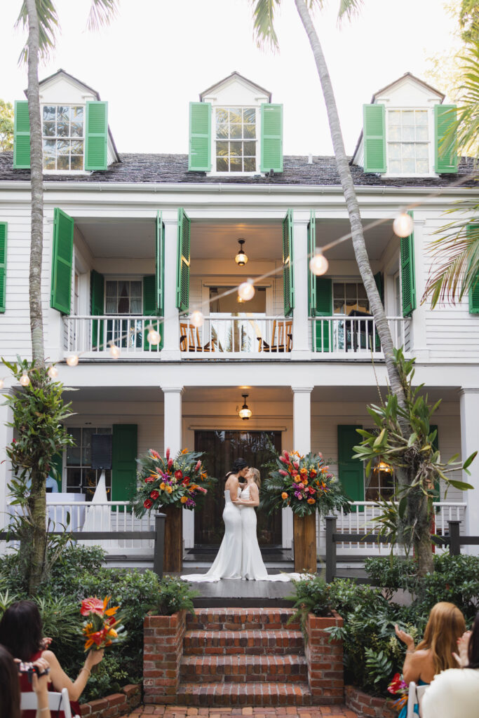 The brides share a kiss in front of the Audubon House during their wedding ceremony.