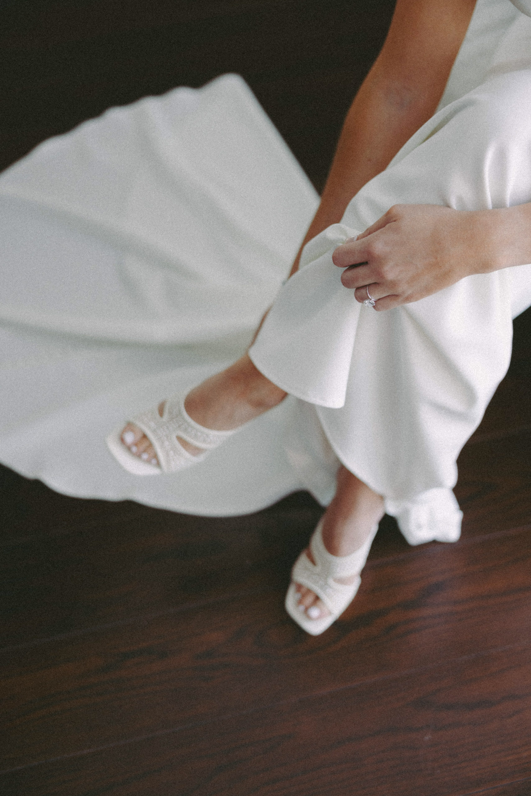 A bride in a white dress and shoes spending a few quiet moments alone before the wedding captured on film