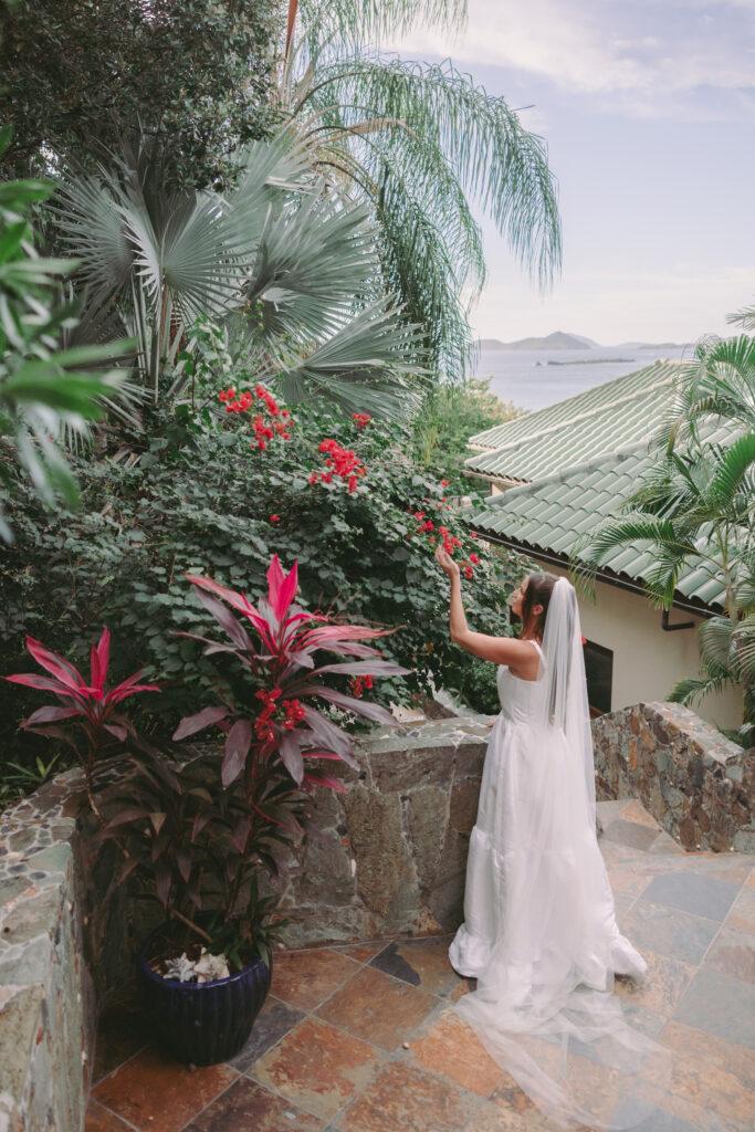 Bride looking at flowers on the steps of a Cruz Bay villa