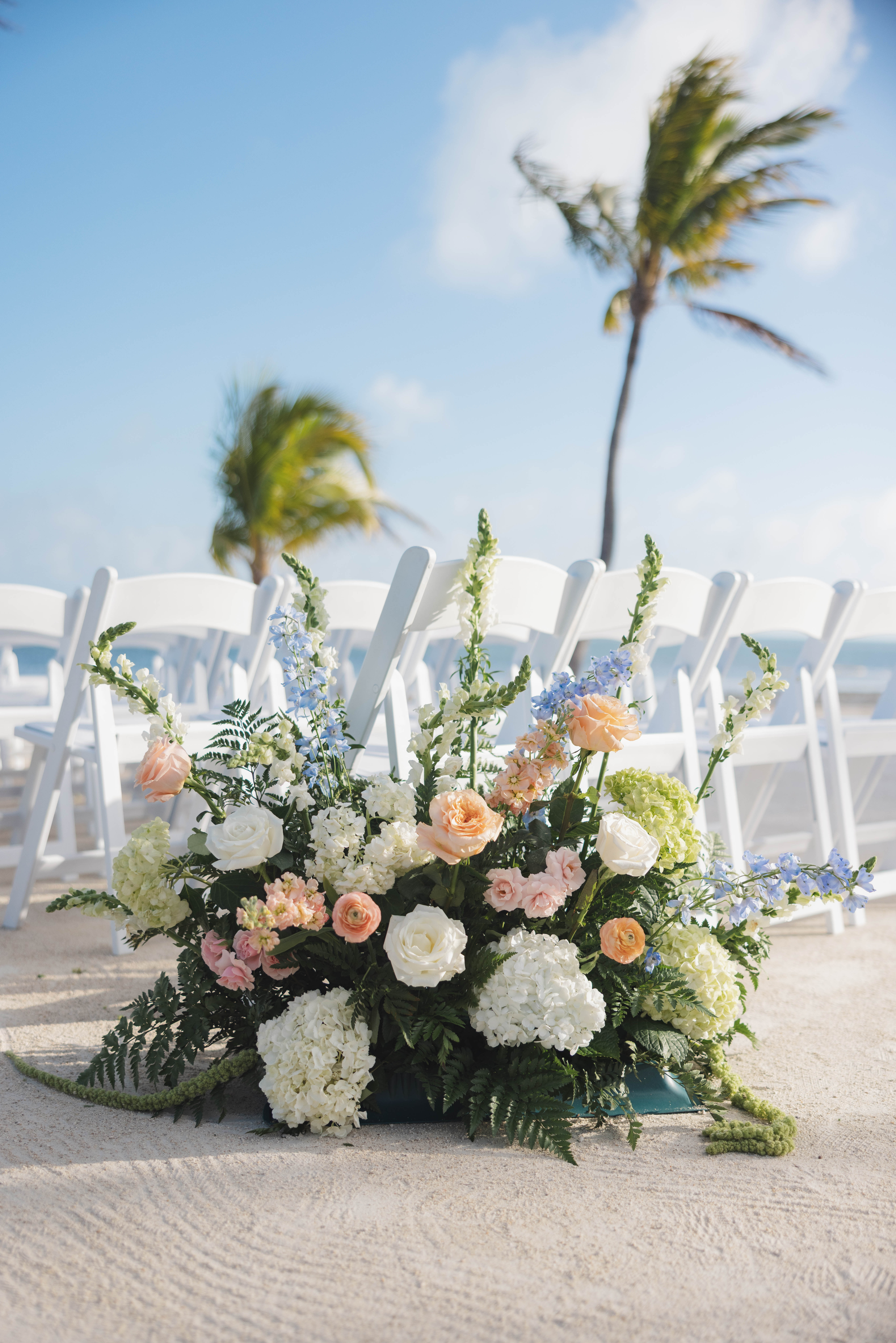 White and peach floral display on the beach during a Cheeca Lodge wedding ceremony
