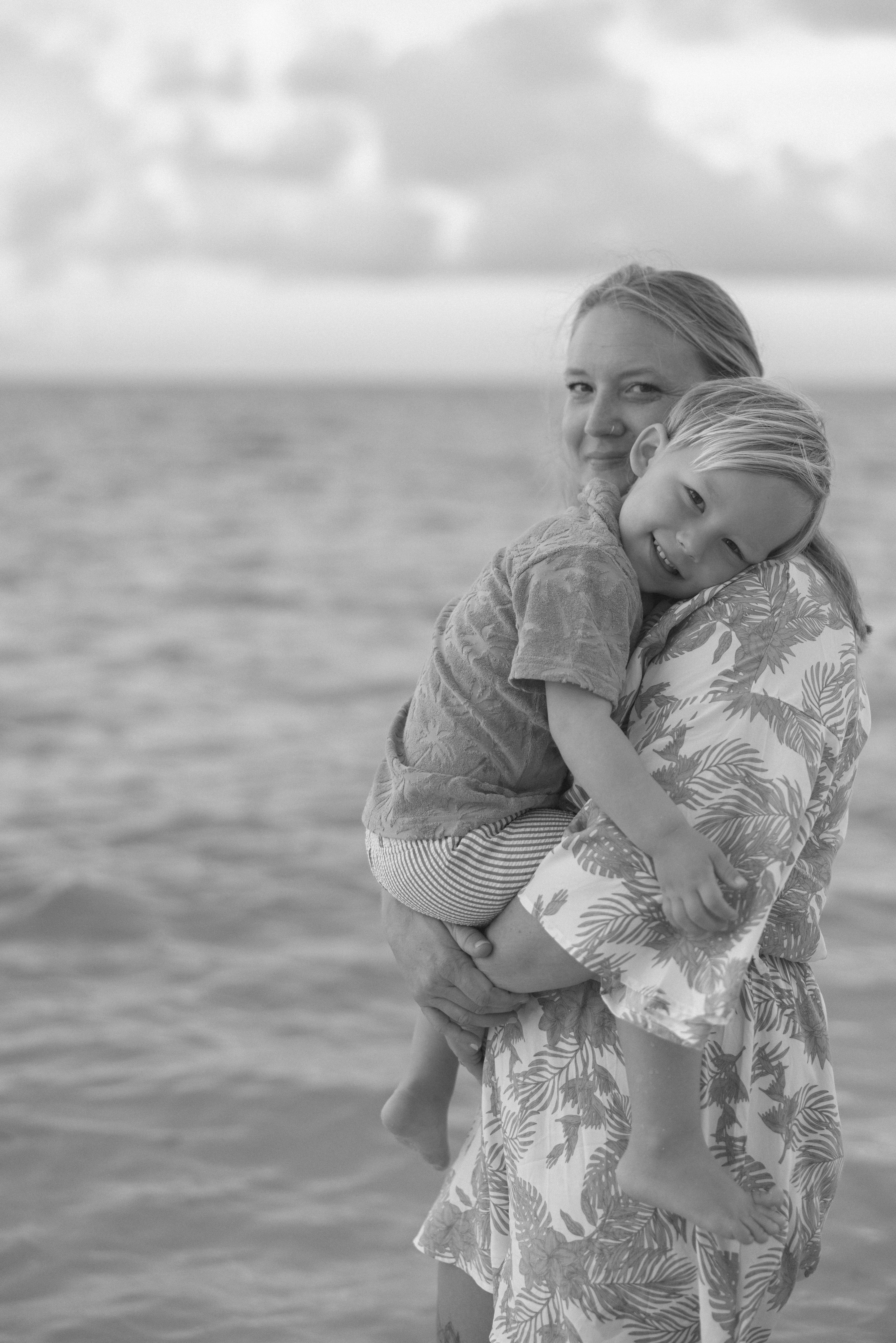 A black and white image of a mother holding her son on a Key West beach