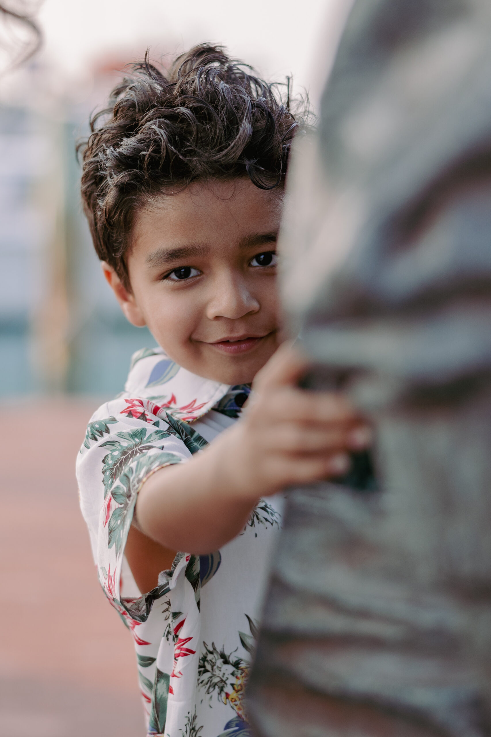 Key West family photographer candidly capturing a boy hiding behind a statue