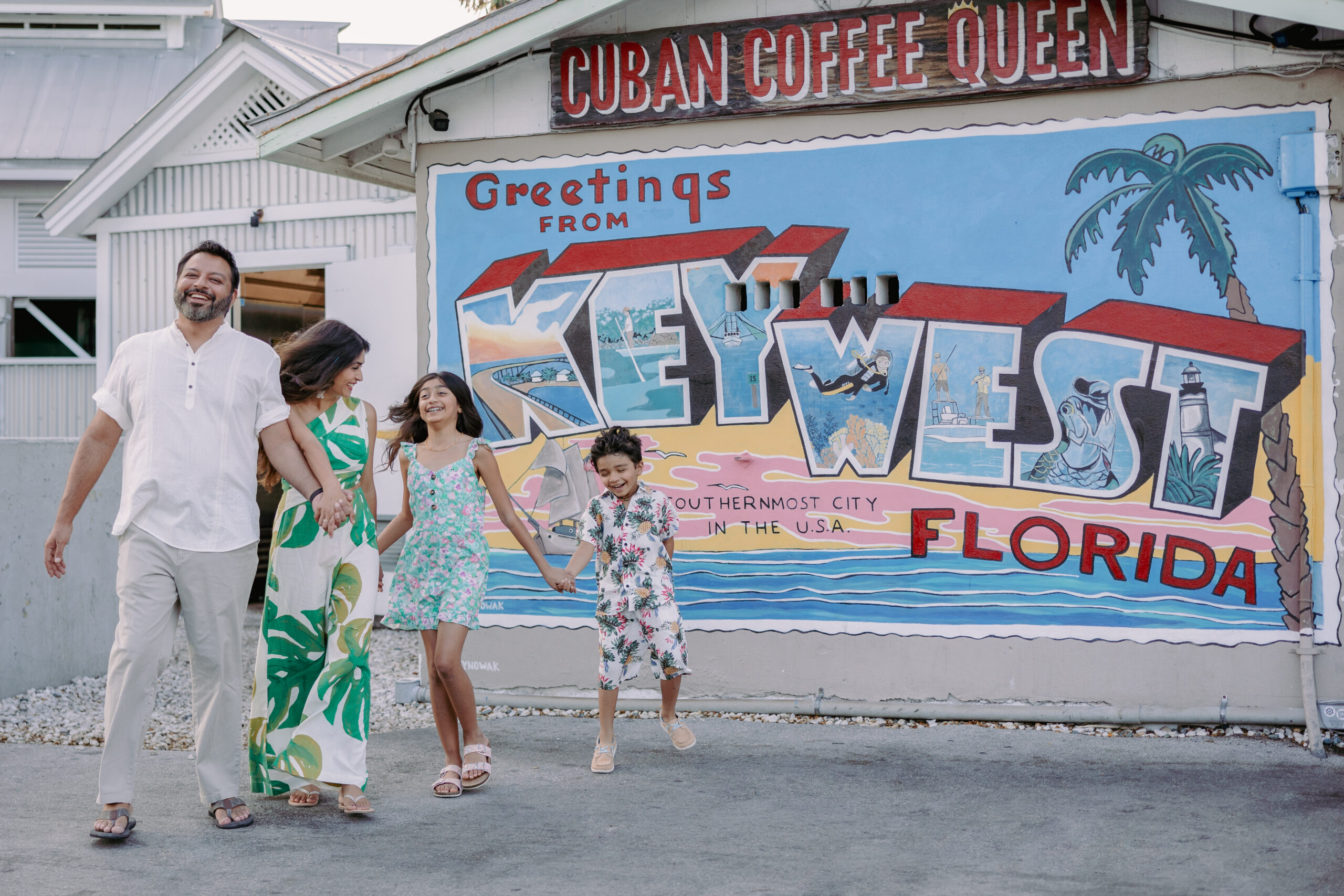 A family in front of the Key West postcard sign in downtown Key West