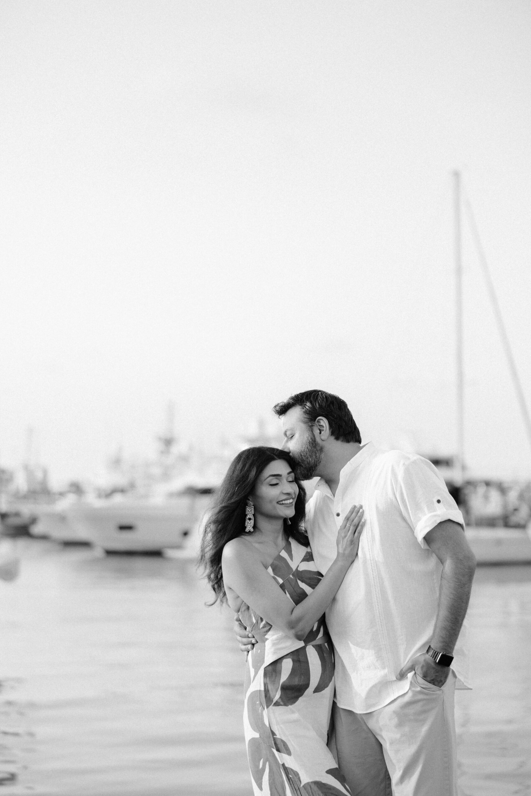 A black and white image of a husband kissing his wife at a Key West marina