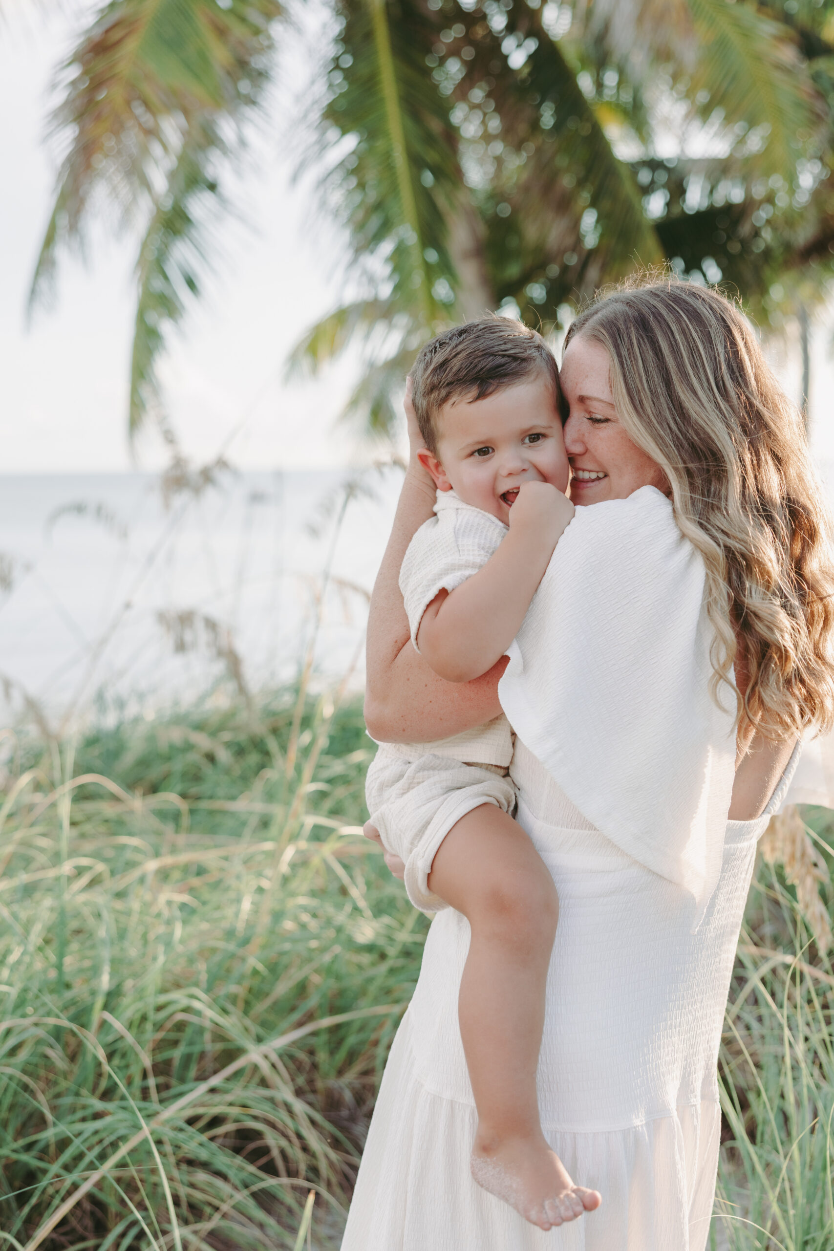 A mother snuggling her son at a Key West beach