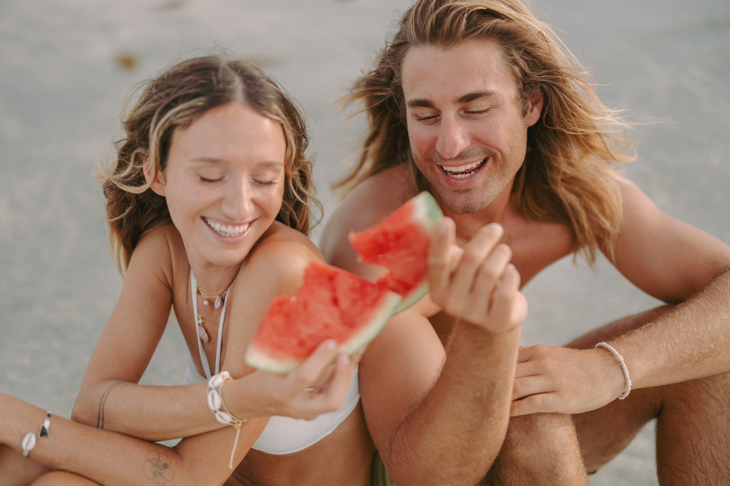 Couple eating watermelon on the beach
