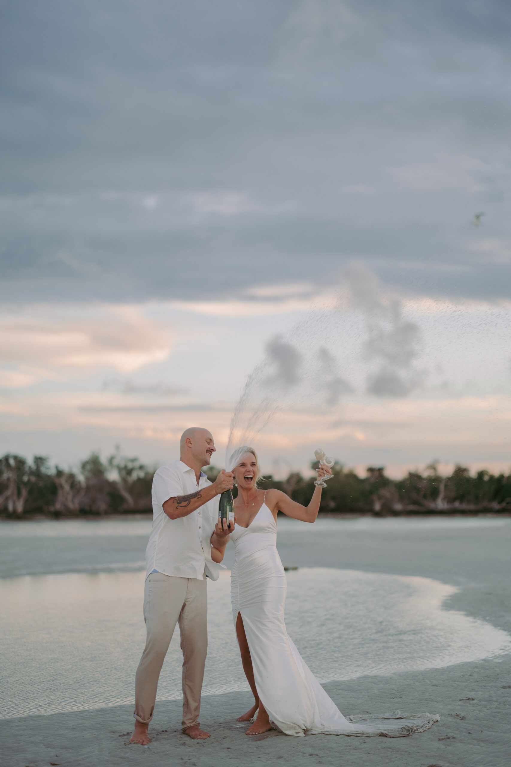 Couple celebrating with champagne during a Key West sunset sandbar session